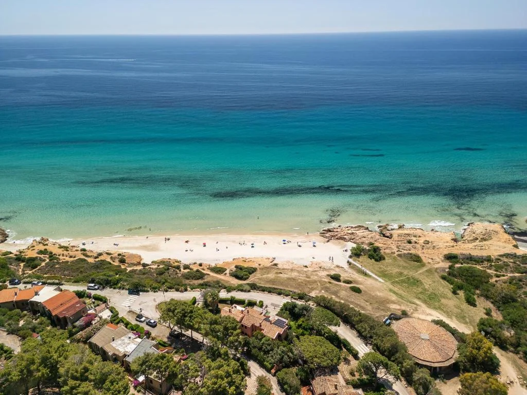 Luchtfoto van het strand van Pinus Village en de turquoise zee op Sardinië